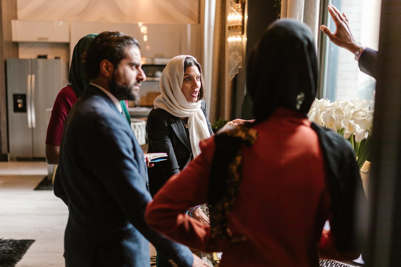 A Woman Wearing Hijab while Talking to Other People